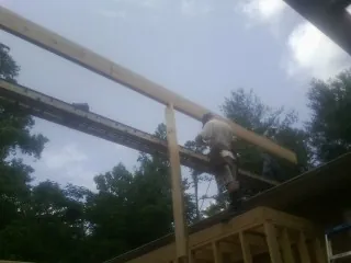 Carpenter setting a ridge beam over a new addition frame — Ice Dam Removal by Roofing Brothers in Fishers Island
