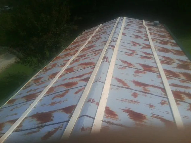 Rusted metal roof panels with new wood purlins before replacement — Storm Damage Roof Repair in Fishers Island by Roofing Brothers
