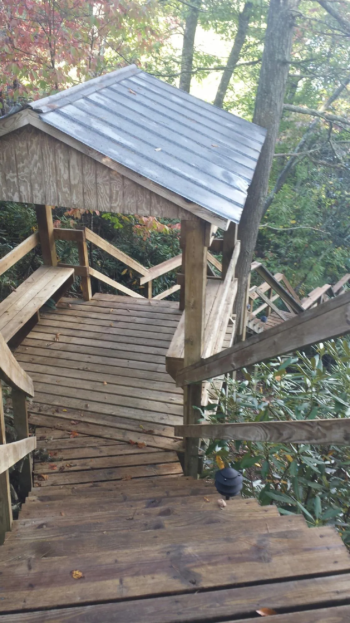 Metal roofed shelter over wooden steps on a wooded walkway — Skylight Repair & Installation work by our crew in Fishers Island