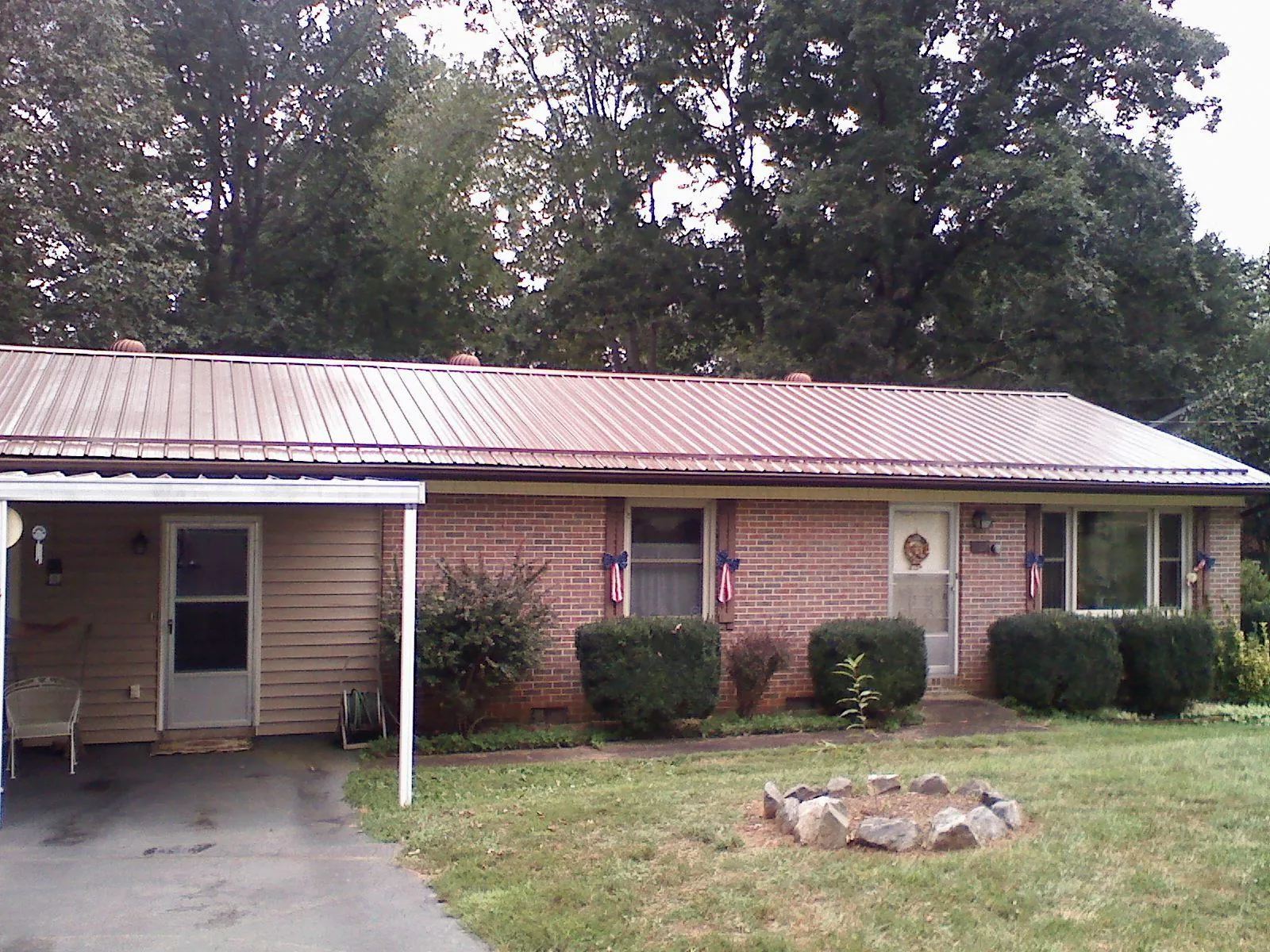 Bronze metal roof and carport on a brick ranch home — Roof Repair work by our crew in Fishers Island